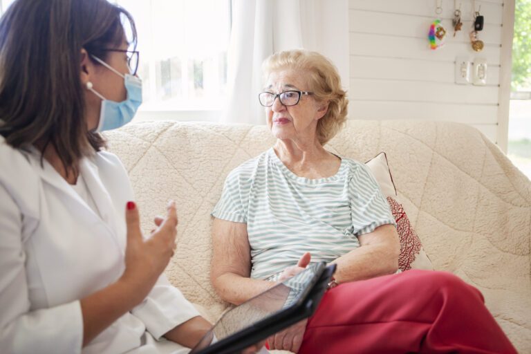 Female home caregiver visiting a senior woman with alzheimer disease at home. Home healthcare concept.